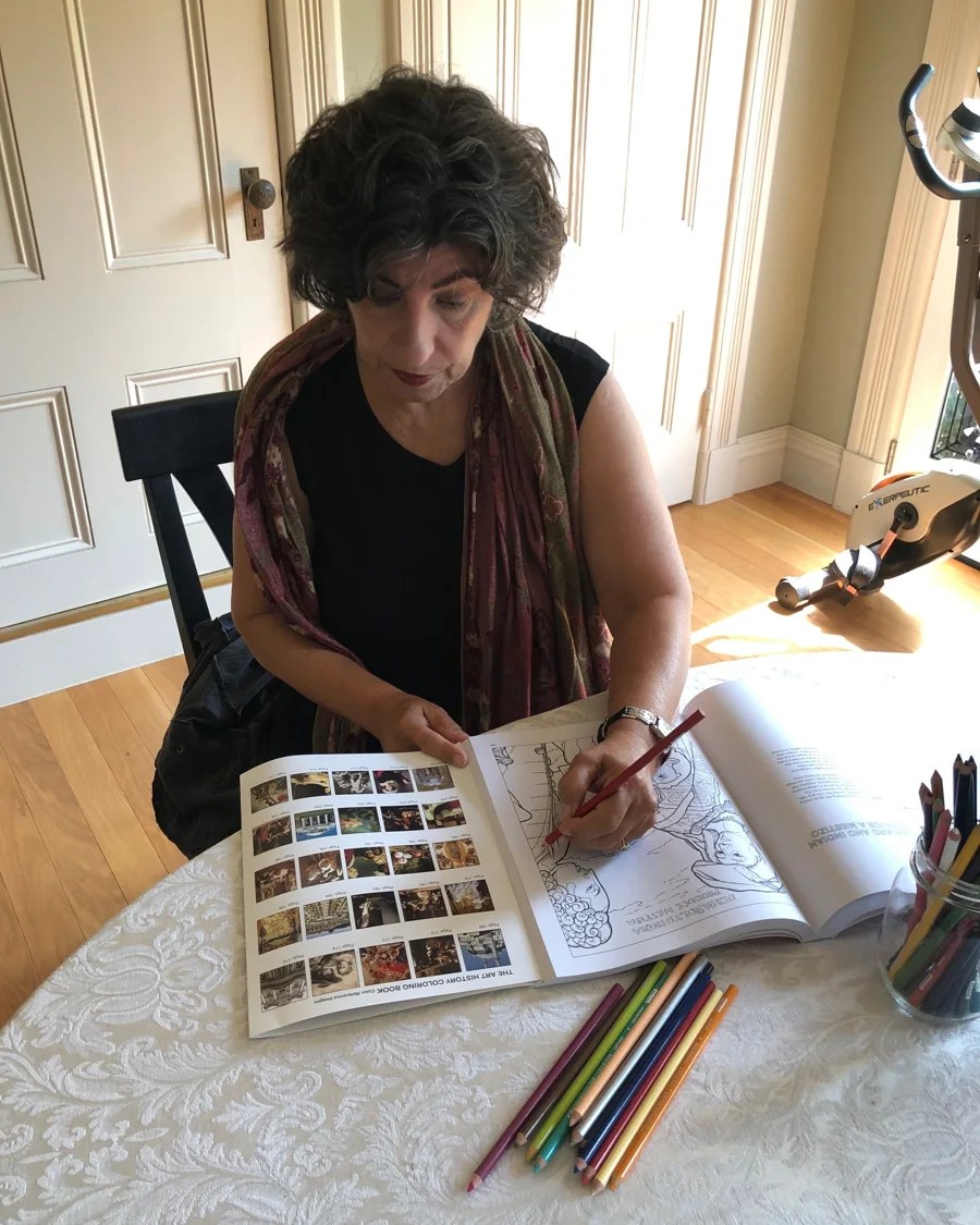 Coloring a page of The Art History Coloring Book at home with colored pencils
